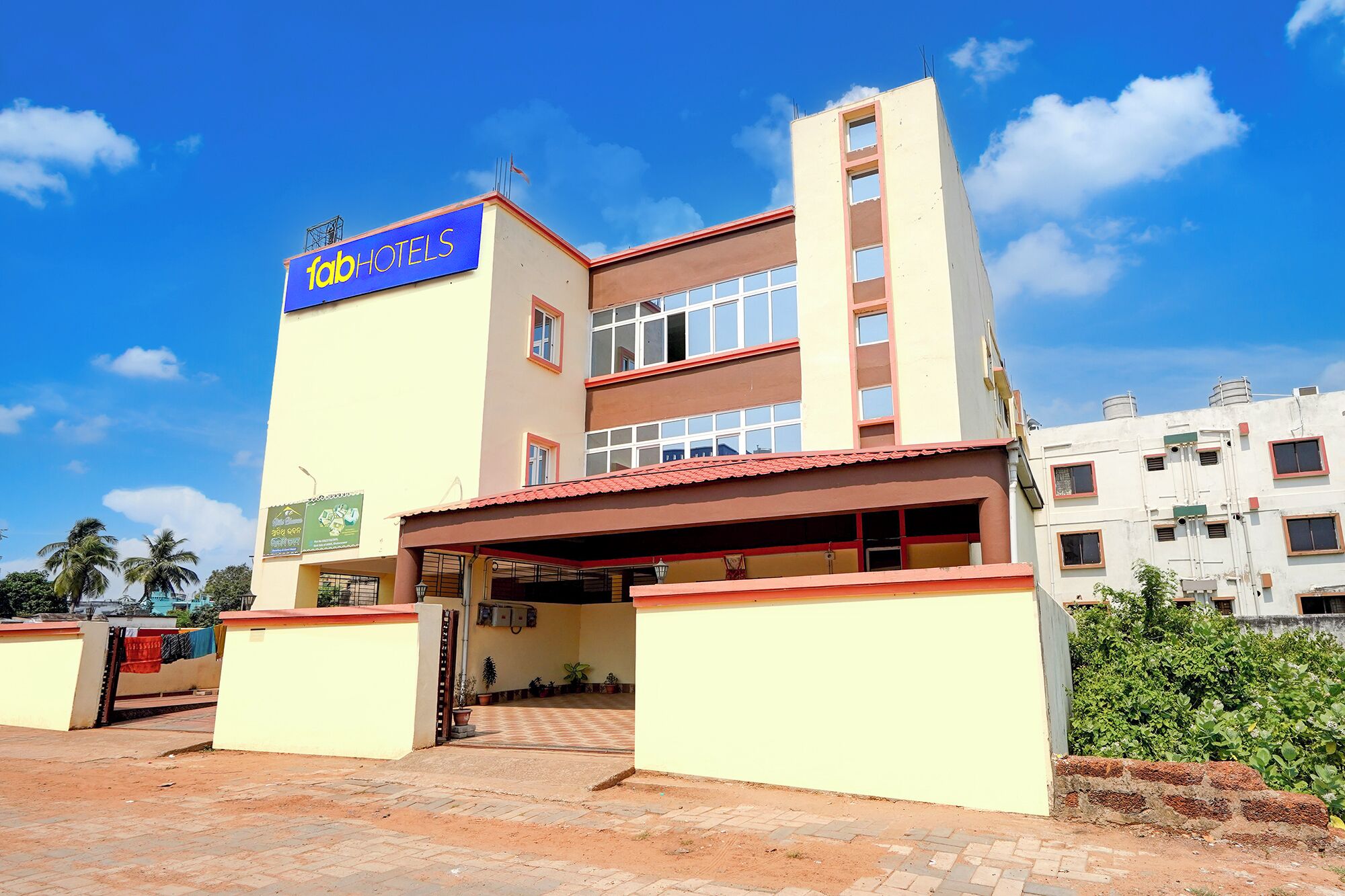 A multi-story building with a prominent 'fabHOTELS' sign, a covered entrance, and a visible staircase leading to the entrance.