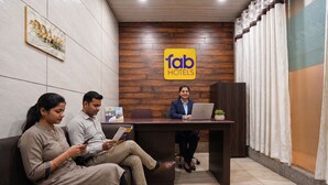A hotel reception area with a wooden wall, a reception desk, and a sign that reads 'fab hotels'. - FabHotel BlueBell Inn (Lucknow)