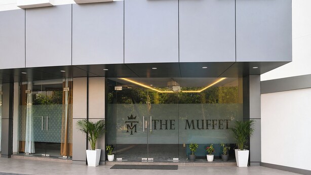 A modern building with a glass facade and the name 'THE MUFFET' prominently displayed. - Fabhotel The Muffet (Indore)