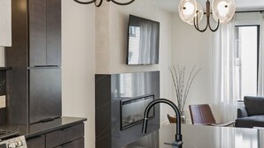 A modern kitchen with a large island, dark cabinetry, and a built-in oven. - Upscale home featuring rooftop lounge with hottub! (Nashville)