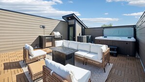 A rooftop patio with outdoor furniture, a grill, and a hot tub. - Exclusive townhome ft. rooftop lounge w/ hot tub! (Nashville)