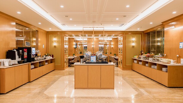 A spacious hotel lobby with a central reception desk, multiple seating areas, and a polished marble floor. - China Mayors Plaza Hotel (Guangzhou)