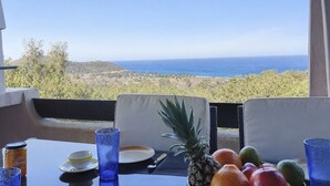Ein Tisch mit Meerblick, einer Ananas und verschiedenen Früchten.