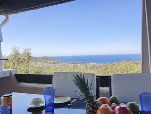 A table with a view of the ocean, a pineapple, and various fruits. - A Saparaccia by Interhome (Sainte Lucie Porto Vecchio)