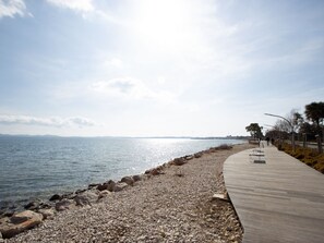 Ein Küstenwanderweg mit Kiesstrand und Holzsteg.