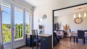 A modern kitchen with a large window, a dining area with a table and chairs, and a view of greenery outside. - Marius Bondil by Interhome (Six Fours)