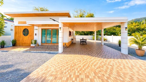 A modern building with a covered patio, a wooden door, and a tiled entrance. - Villa Ao Nang Krabi with a free car (Krabi)