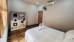 A bedroom with a bed, a wardrobe, a fan, and a door. - Villa Ao Nang Krabi with a free car (Krabi)