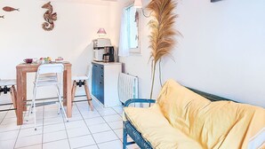Ein kompakter Wohnbereich mit Essbereich, Küchenzeile und einer Couch.