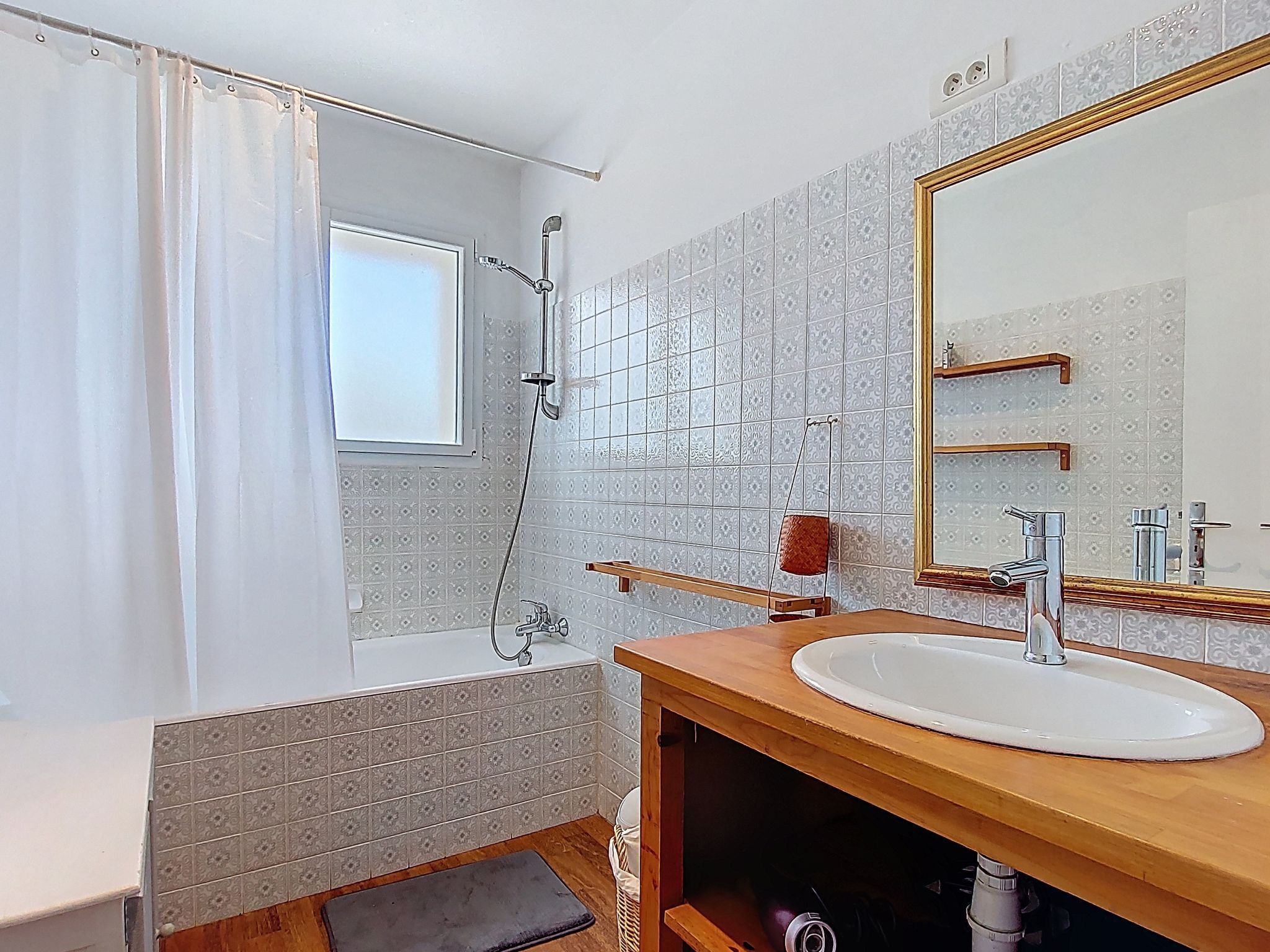 A bathroom with a bathtub, a shower, a sink, and a large mirror.