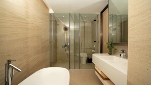 A modern bathroom with a glass-enclosed shower, a white bathtub, and a large mirror above the sink. - The Five Hotel & Resort Evara - 24 Hours stay (Hanoi)