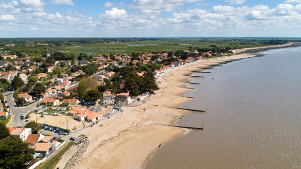 Un pueblo costero con playa, casas e iglesia.