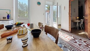 Una cocina con una mesa de comedor, sillas y vistas al exterior.