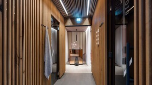 A corridor with wooden paneling, a towel rack, a small table with flowers, and a sign with text. - 4 Star Holiday Home in Travemunde (Lübeck)