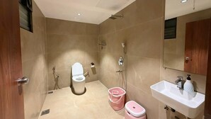 A bathroom with a toilet, shower, sink, and mirror. - 7 Tree Resort & Restaurant (Paud)