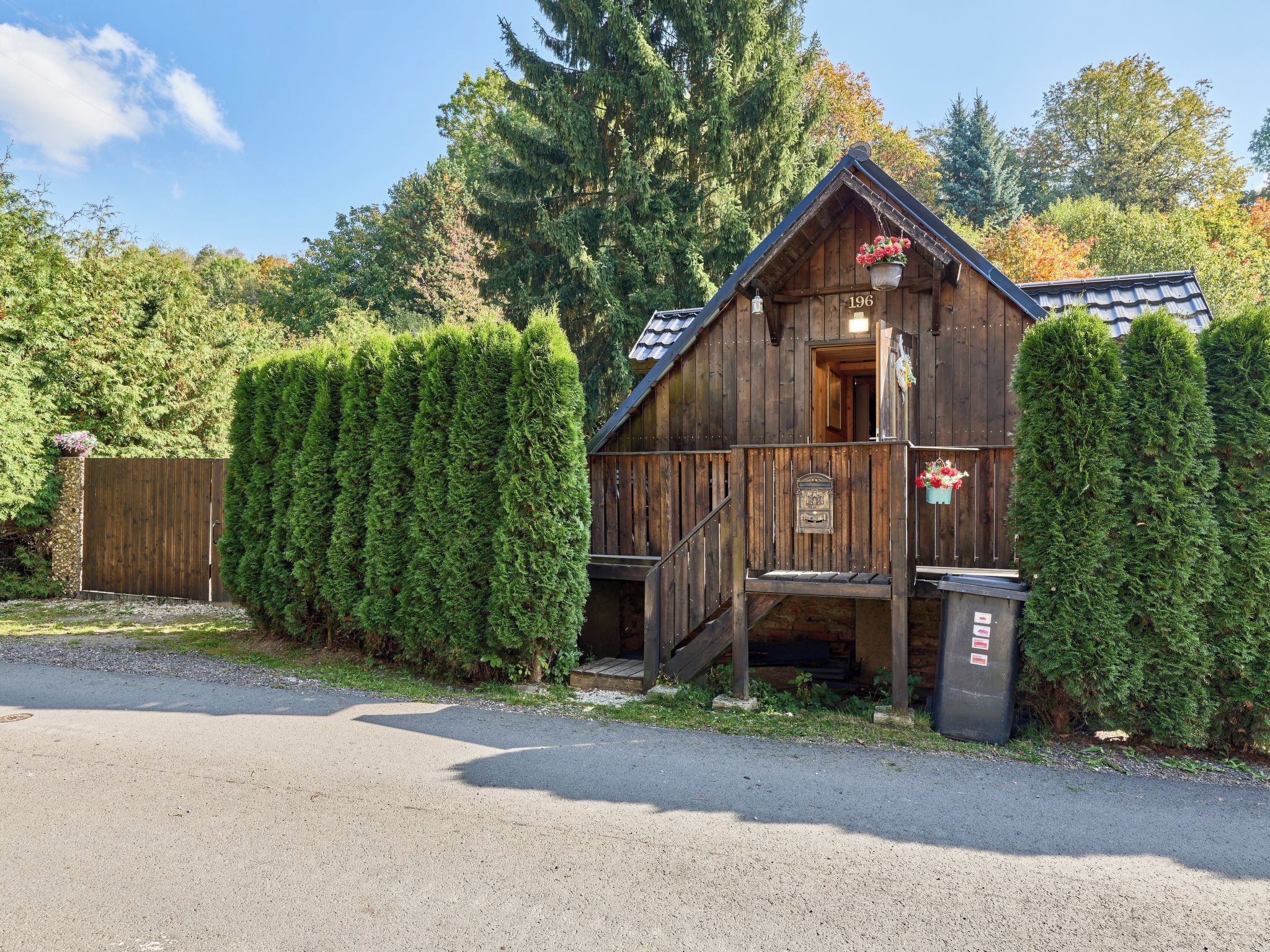 Un rustico chalet in legno con un cartello con il numero '196', una scala in legno e un piccolo portico.