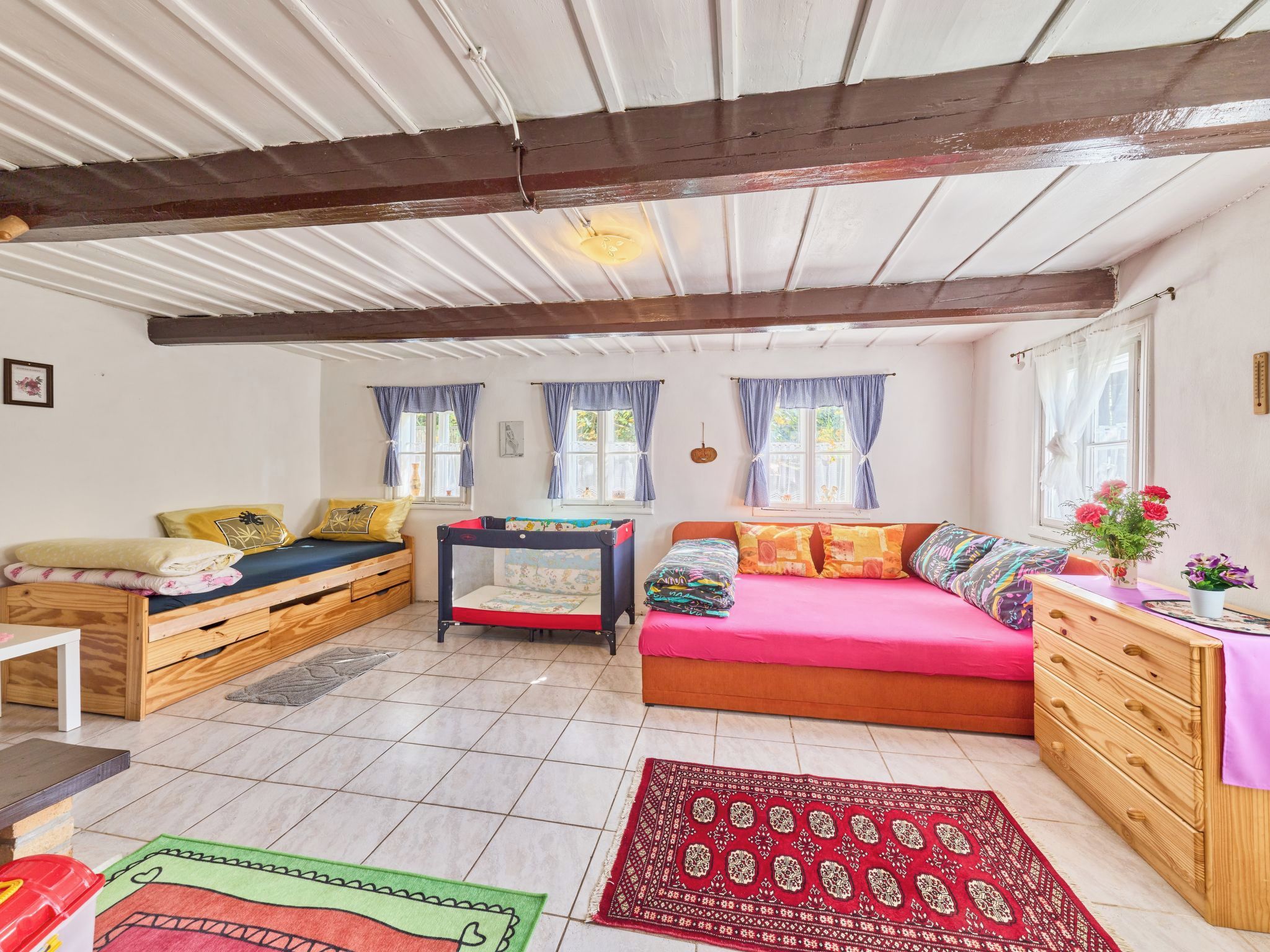 Une pièce confortable avec un lit, un canapé, une petite table et une commode.