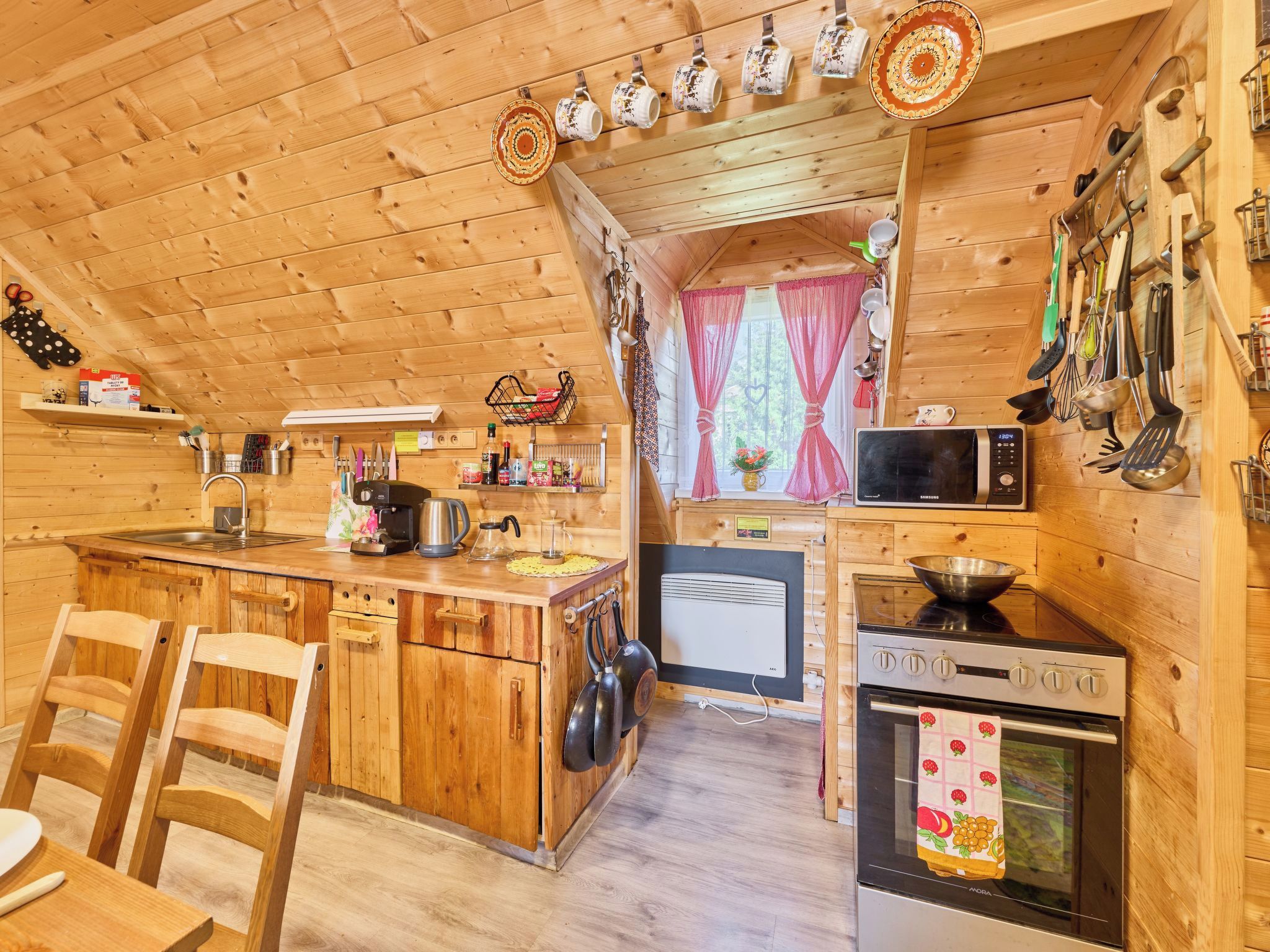 Una cocina acogedora con paredes de madera, una isla central y un comedor con sillas.