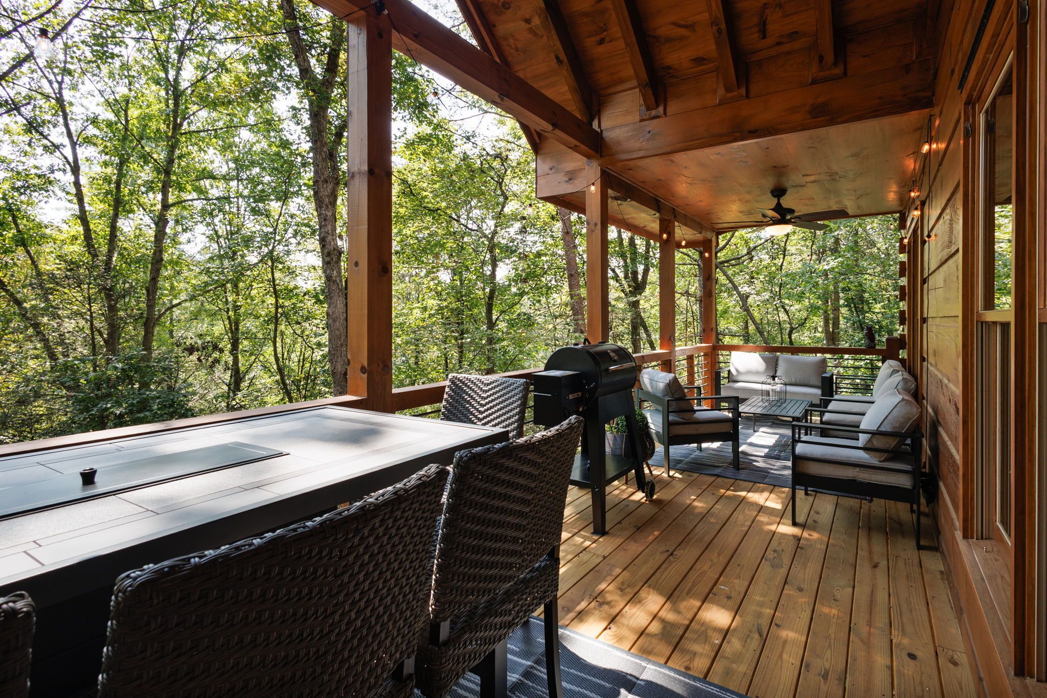 Une terrasse extérieure couverte, équipée d’une table, de chaises et d’un barbecue.