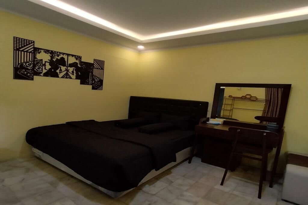 Une chambre à coucher comprenant un lit, un bureau, une chaise et un mur orné de panneaux décoratifs.