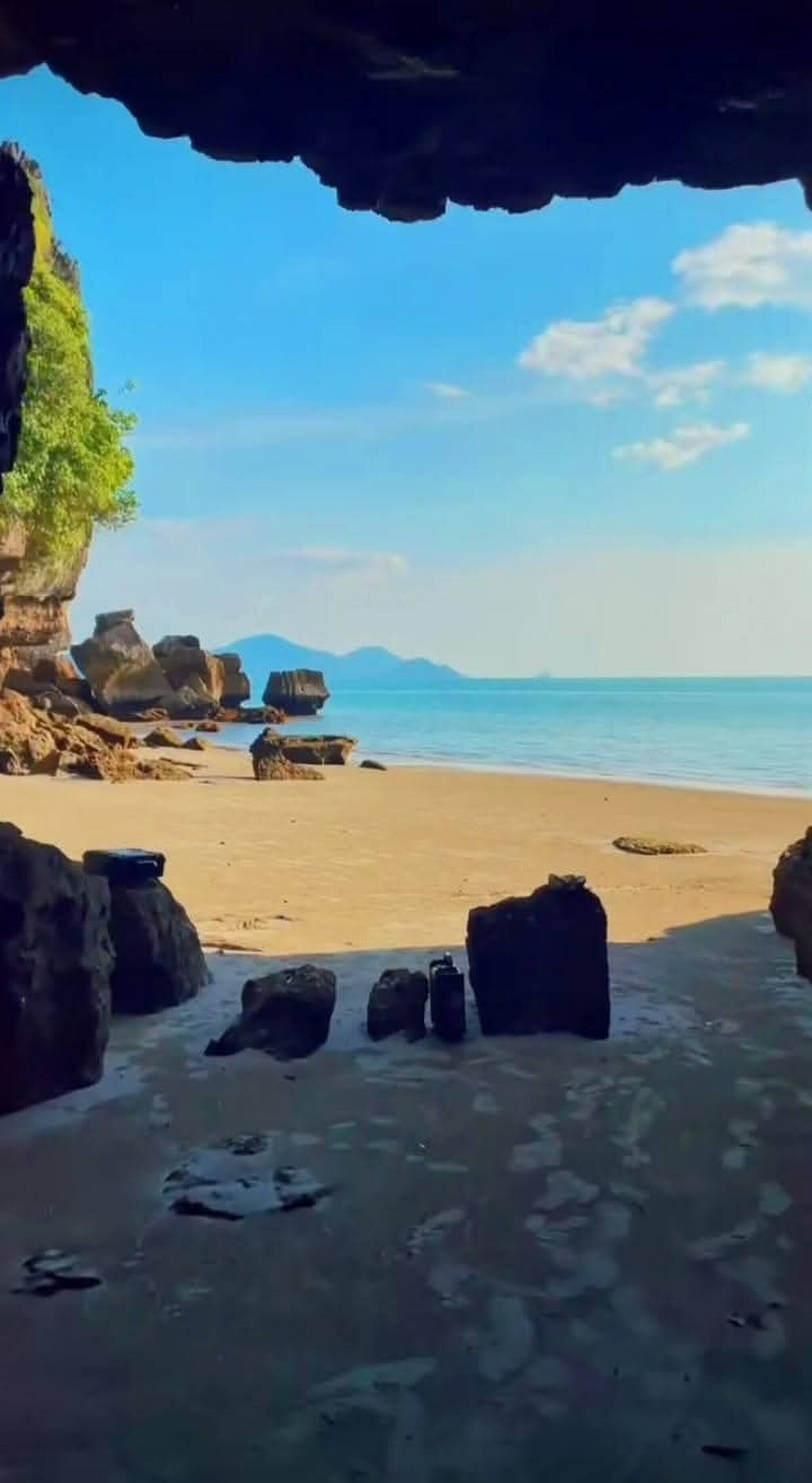 A beach with rocks and a clear sky.
