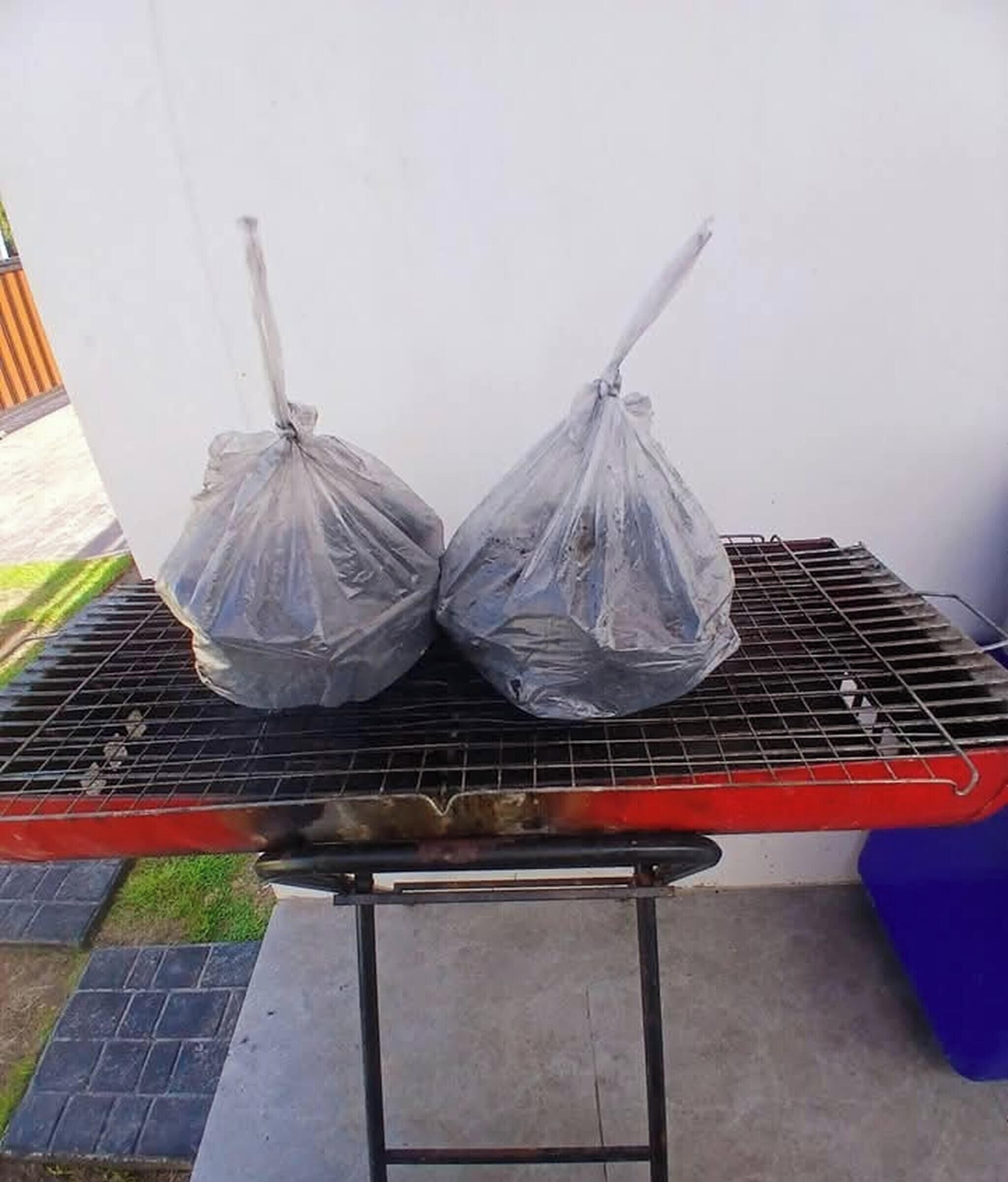 Uma churrasqueira com dois recipientes tampados.