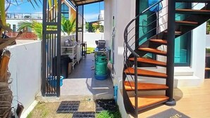 A modern building with a spiral staircase, a covered outdoor area, and a welcome mat.