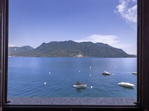 Blick auf einen ruhigen See mit mehreren Booten, einem Berg im Hintergrund und einem klaren Himmel.