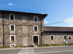 A stone building with multiple windows and a door, a bicycle parked outside, and a clear sky. - Leonard Lake by Interhome (Ghiffa)