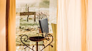 A window with a view of a garden, a metal table with a vase, and a wooden bench. - Appartement in Zinnowitz mit Grill by Interhome (Zinnowitz)
