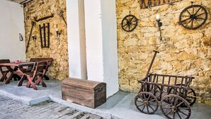 A rustic stone wall with a wooden cart and a table with benches. - Fewo Römerweg by Interhome (Neustadt an der Weinstraße)