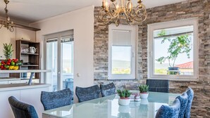 Eine moderne Küche mit Steinwand, einem Glastisch und einer Chandelier.