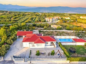 A residential property with a swimming pool, red-roofed buildings, and a view of the sea and mountains. - Holiday Home Meri by Interhome (Pridraga)