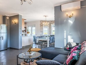A modern living room with a sofa, coffee table, and a view of the kitchen and dining area. - Holiday Home Meri by Interhome (Pridraga)