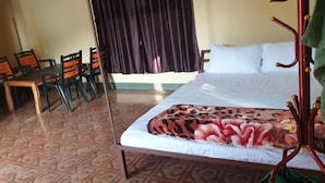 A room with a bed, a dining table with chairs, and a curtain. - Elephant Garden Hotel and Resort (Kanchanrup)