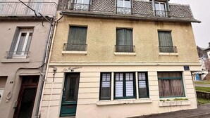 Un immeuble de deux étages, avec une entrée au rez-de-chaussée, un balcon à l’étage supérieur et une enseigne indiquant « La Résidence ».