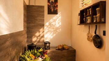 Cocina con encimera de madera, pileta de acero inoxidable y un colgador para ollas.