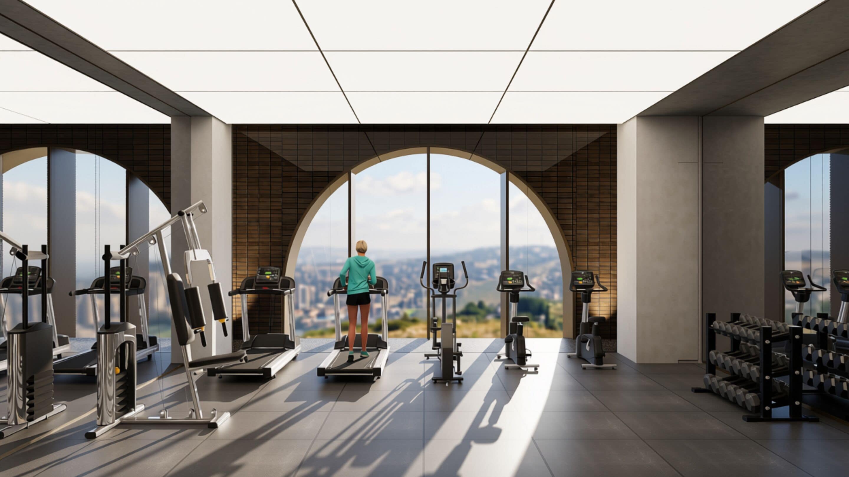Un gimnasio con un amplio ventanal de arco que ofrece vistas a la ciudad.