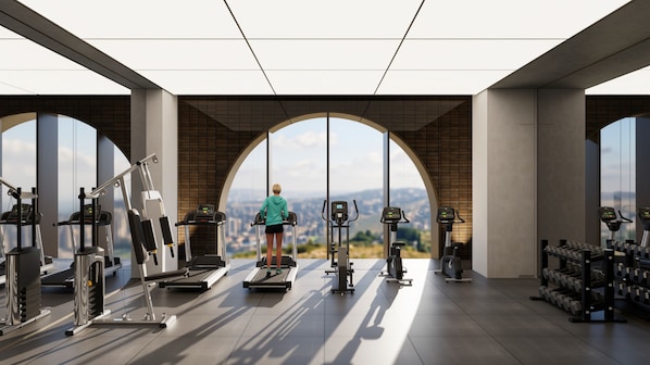 Un gimnasio con un amplio ventanal de arco que ofrece vistas a la ciudad.