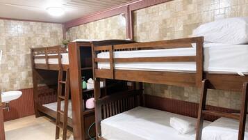 A bunk bed room with a sink and storage cabinets.