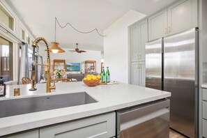 Eine moderne Küche mit Edelstahlgeräten, einer weißen Arbeitsplatte und einem eingebauten Geschirrspüler.
