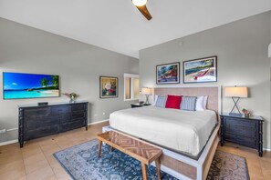 A bedroom with a bed, dresser, nightstands, lamp, and artwork on the walls. - Kapalua Ridge | Ocean View 2 BR, Sleeps 8 | Car Incl. w/ 6+ Nights | KRV ML-3942 by KBM (Lahaina)