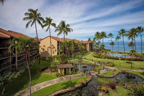 A resort with multiple-story buildings, a swimming pool, palm trees, and a small pond. - Papakea | Ocean View 7 BR, Sleeps 20 | Car Incl. w/ 6+ Nights | PKC ML-3966 by KBM (Lahaina)