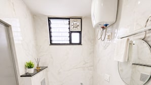 Ein kleines Badezimmer mit Toilette, Waschbecken und Dusche.