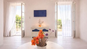 A room with a white console table, a statue, and a vase with flowers. - Gaea Pylos: Spacious family house near beaches (Pylos Nestoros)