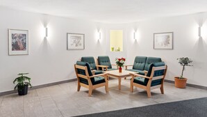 Ein Zimmer mit einem runden Tisch, vier Stühlen und einer Topfpflanze.