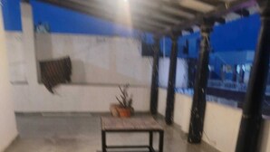 Un espace intérieur spacieux doté d’un sol en béton, d’une petite table et d’une plante en pot.