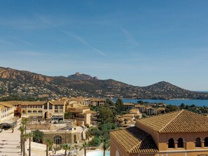 A coastal town with Mediterranean architecture, a central square, and a mountain in the background. - Village Cap Estérel - L'Esquinade by Interhome (Agay Village Cap Esterel)