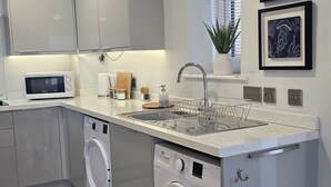 Eine moderne Küche mit integrierten Geräten, einer Spüle und einer Waschmaschine.