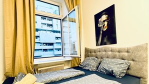 A bedroom with a bed, a window, a radiator, and a painting on the wall. - Modern 3BR Apartment 10 Min to FAC Platz (Wien)